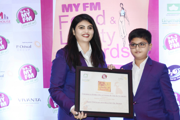 archana kute and aryen kute holding Most Popular and Healthy Oil Brand Award 2018 for Tirumalla Oil